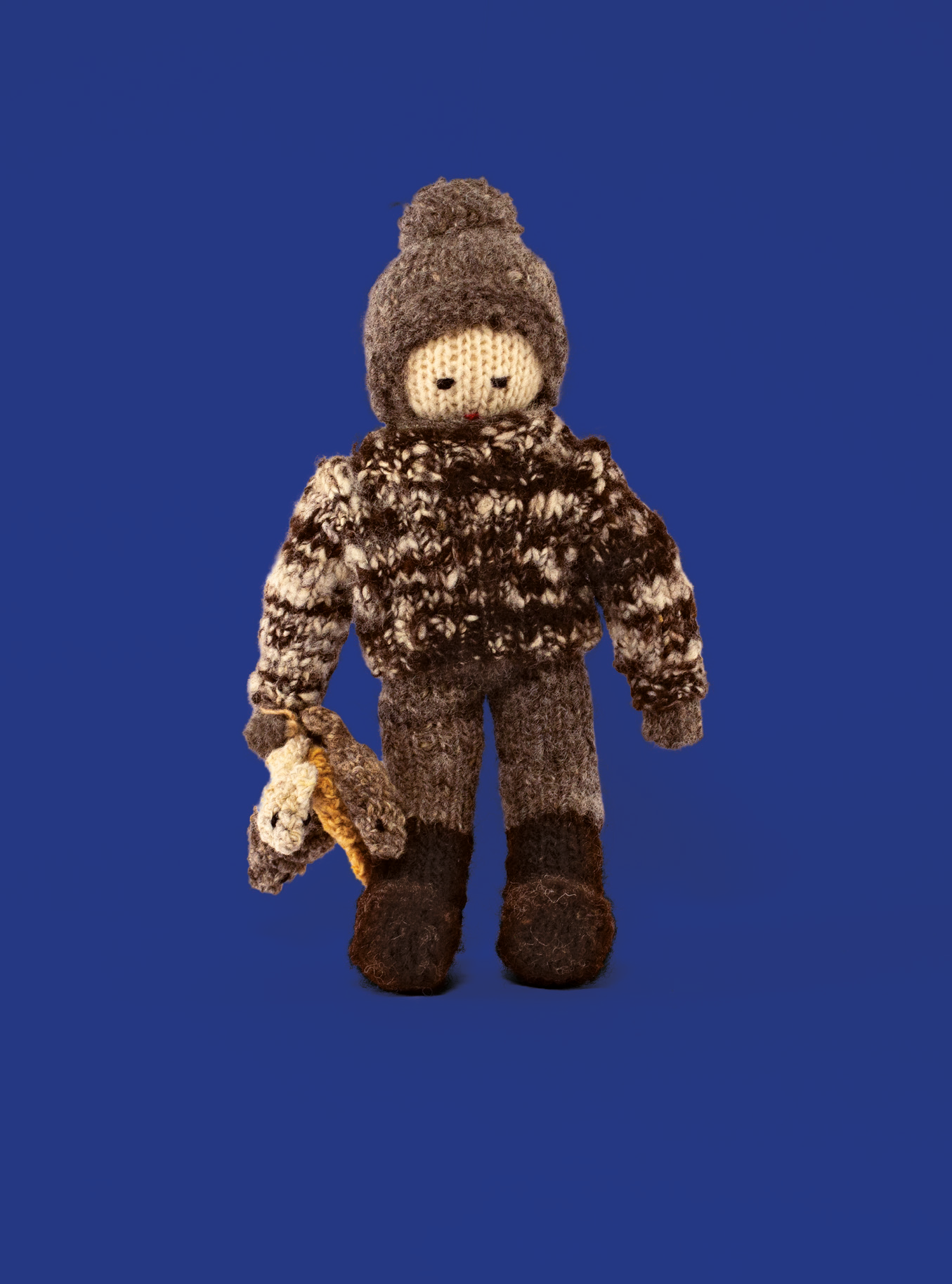 Muñeco de lana que representa a un pescador sobre fondo azul.